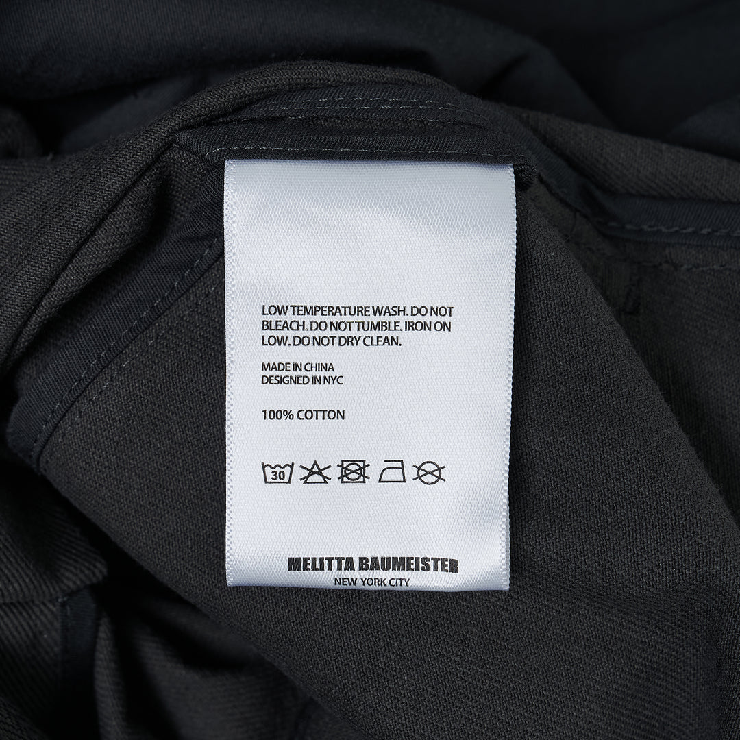 Melitta Baumeister charcoal wide-leg cargo culottes with high waist, sculptural rounded zip utility pocket, and A-line silhouette, shot flat on white background