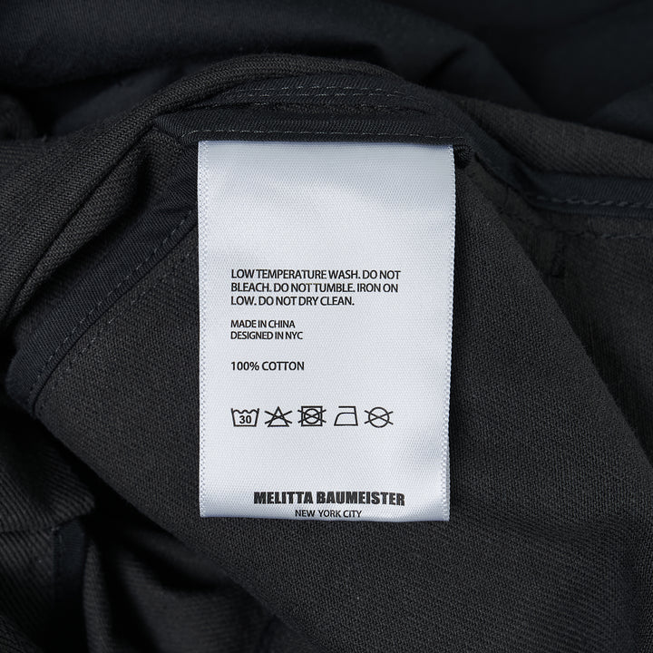 Melitta Baumeister charcoal wide-leg cargo culottes with high waist, sculptural rounded zip utility pocket, and A-line silhouette, shot flat on white background
