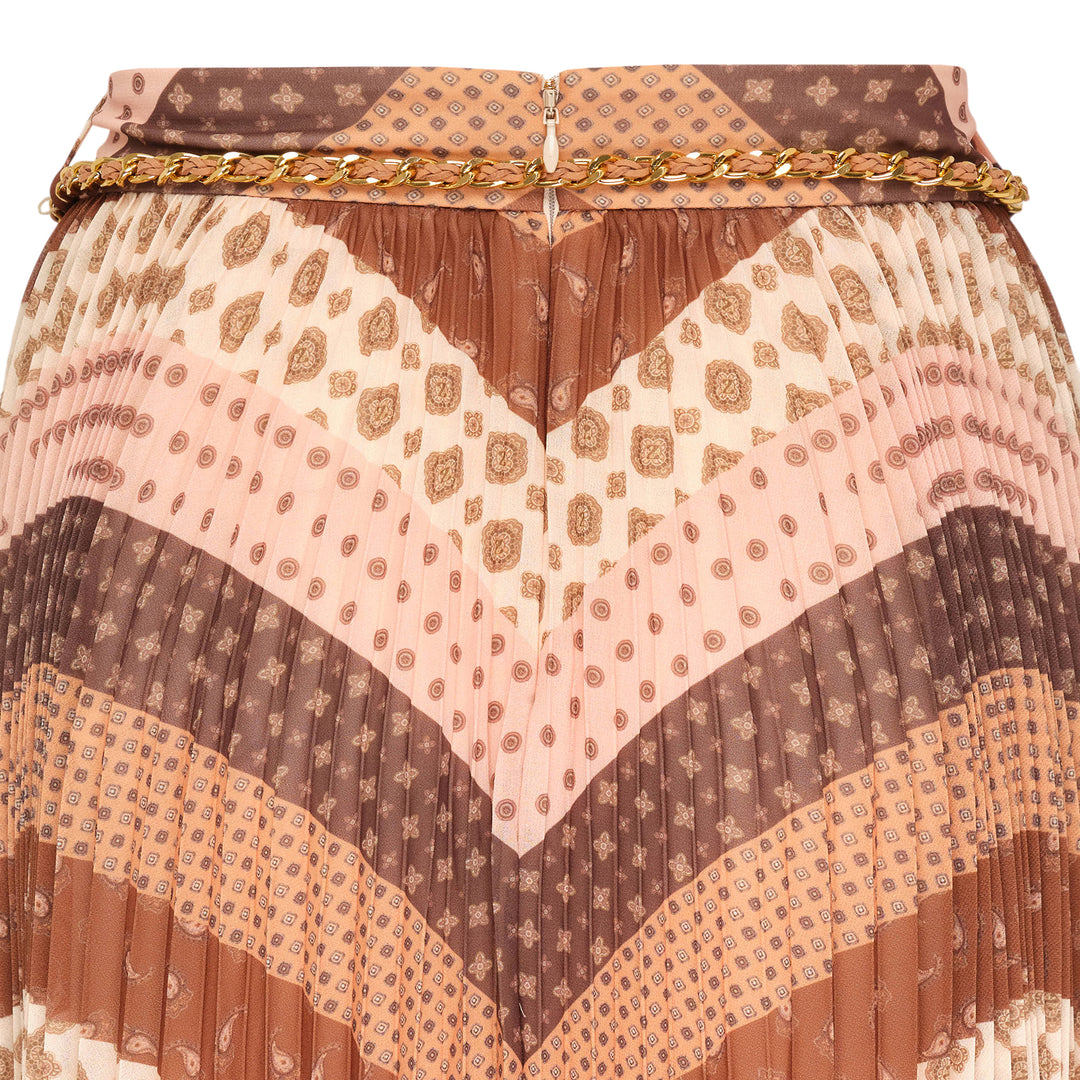 Zimmermann Sunray Pleated Maxi Skirt in warm-toned chevron mixed prints of leopard, paisley, and geometric patterns, with gold chain belt at the waist