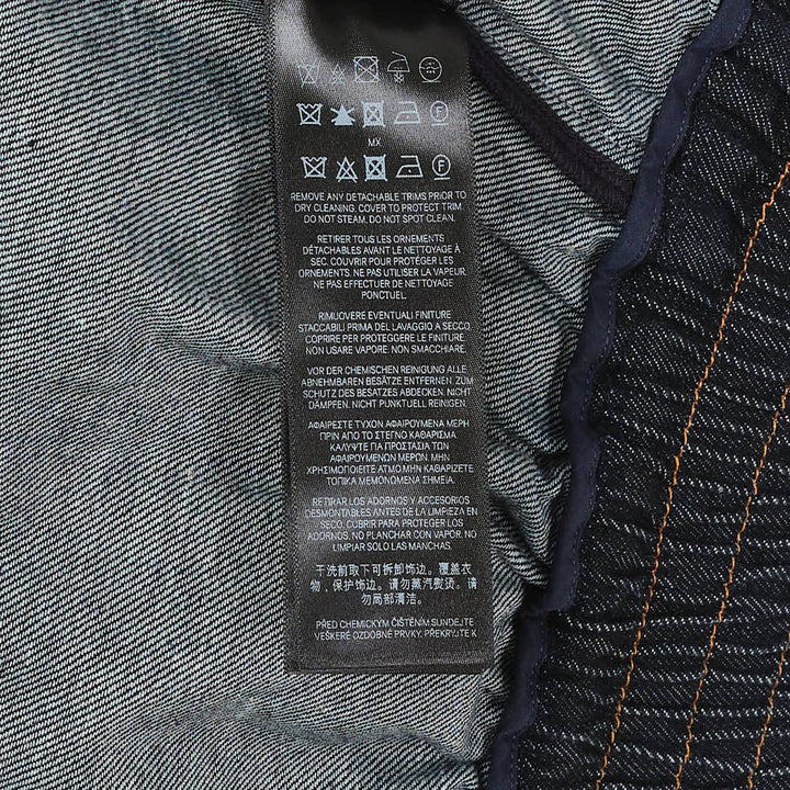 Zimmermann Denim Cape Top in dark indigo, back view, showing V-shaped gathered yoke, amber contrast topstitching, structured collar, and full sweeping hemline