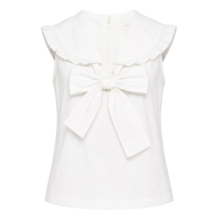 SHUSHU/TONG white sleeveless woven top with ruffled shawl collar and large oversized self-fabric bow at the centre front, photographed against a white background