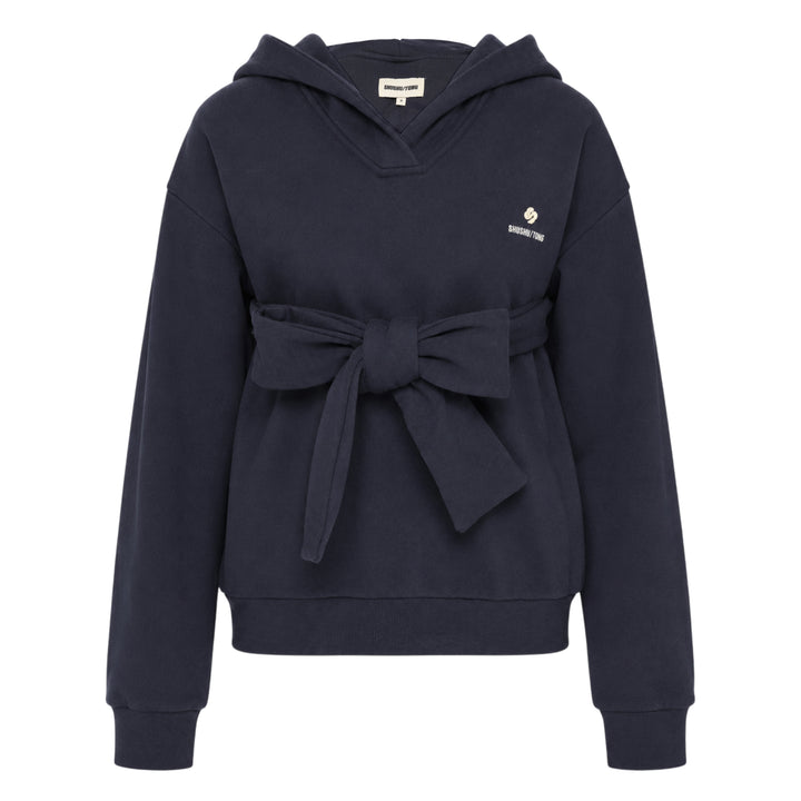 SHUSHU/TONG navy Tie Front Bow Hoodie with an oversized self-fabric bow at the waist, open V-neckline, and embroidered logo on the chest