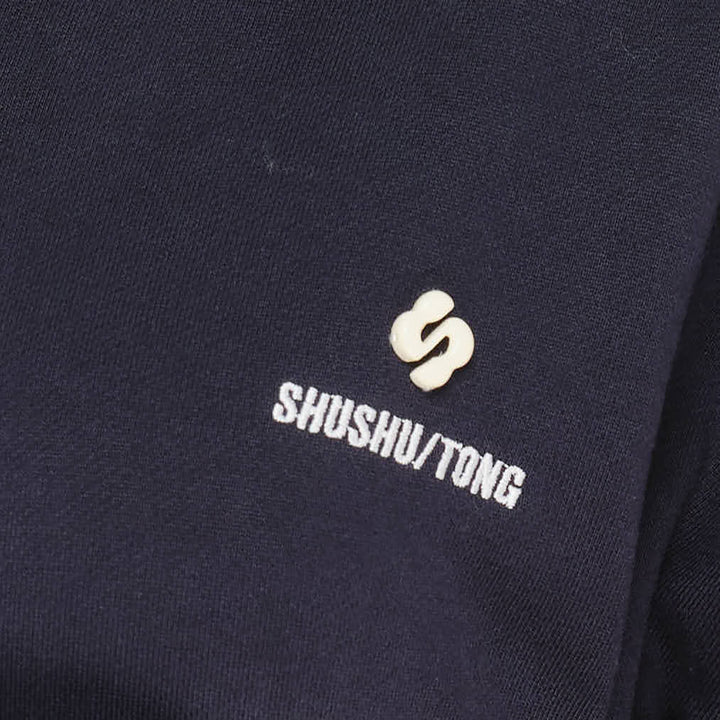 SHUSHU/TONG navy Tie Front Bow Hoodie with an oversized self-fabric bow at the waist, open V-neckline, and embroidered logo on the chest