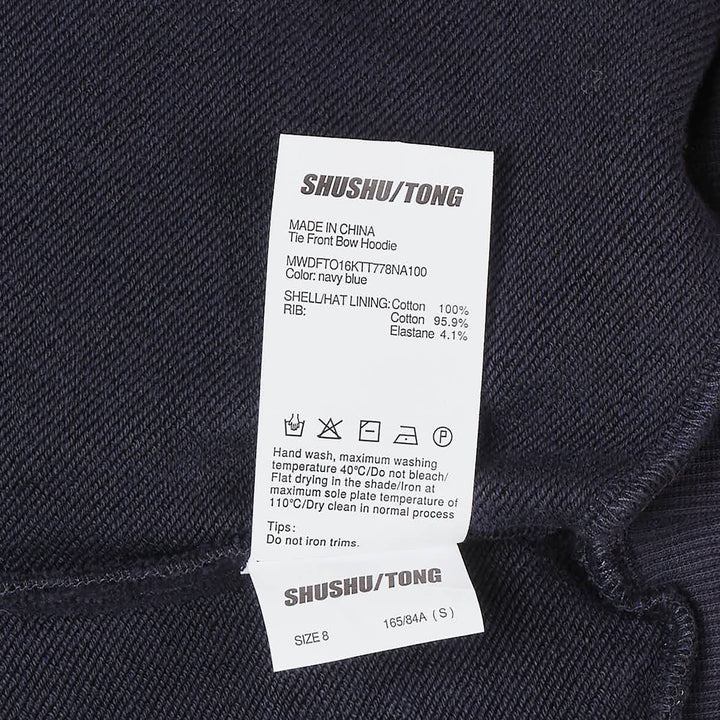SHUSHU/TONG navy Tie Front Bow Hoodie with an oversized self-fabric bow at the waist, open V-neckline, and embroidered logo on the chest