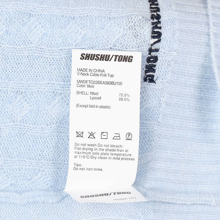 SHUSHU/TONG V-Neck Cable Knit Sweater in baby blue with open collar, all-over cable texture, and ribbed cuffs and hem