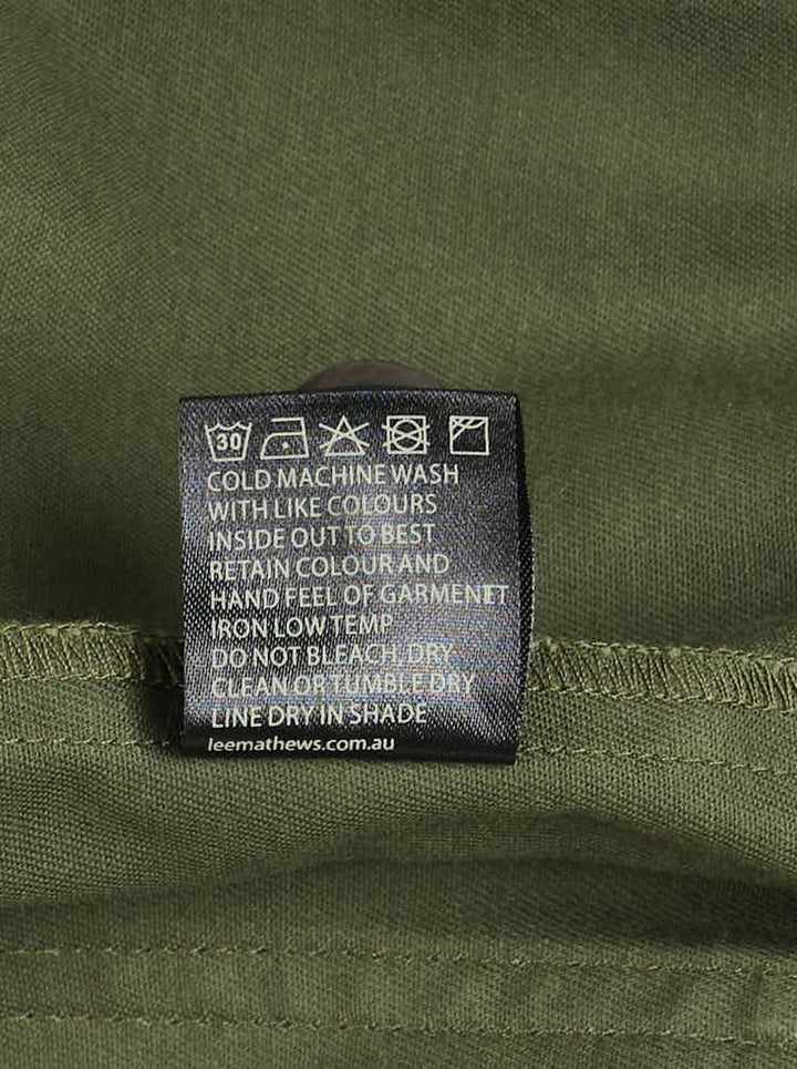 Lee Mathews Harper Drill Utility Jacket in washed khaki cotton drill, featuring a stand collar, button-through placket, drawstring waist, and large flap hip pockets - view 3