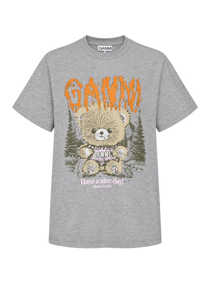 Ganni relaxed graphic cotton tee in heathered grey with orange flame-style Ganni logo, illustrated teddy bear holding a Ganni sign, pine forest motif, and 'Have a nice day! Please recycle' text on the front
