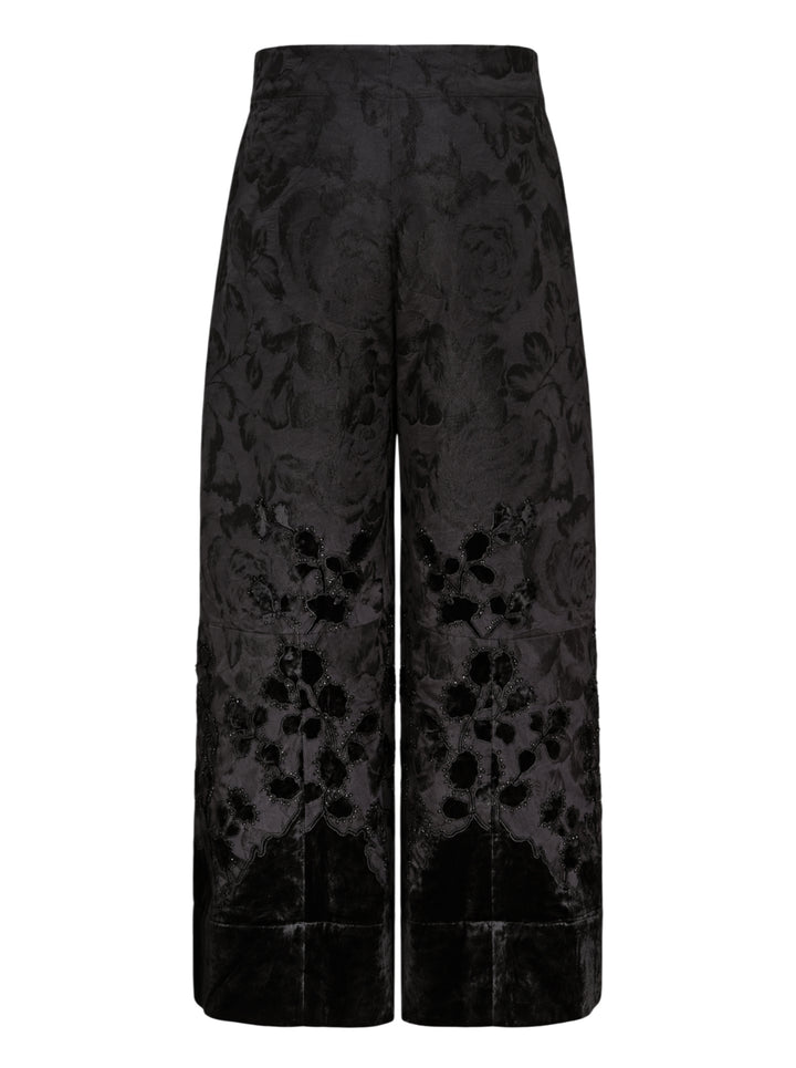 Biyan black lamé jacquard wide leg trousers with all-over rose brocade pattern, broderie anglaise cutwork floral hem border with beaded scallop edging, and velvet cuff finish, photographed flat on a white background - view 2