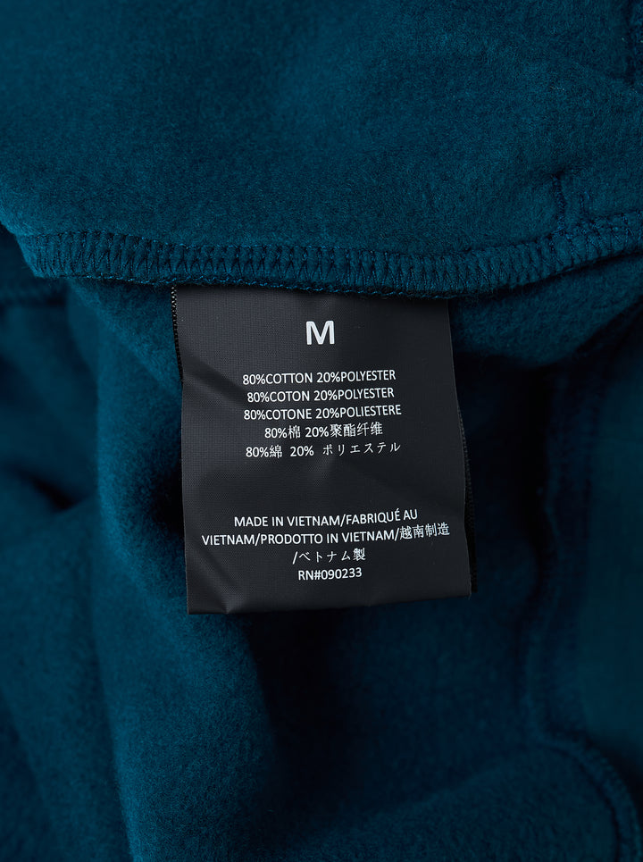 Fear of God Essentials Classic Raglan Hoodie in deep teal with white script logo across the chest and tonal textured shoulder panels - view 3
