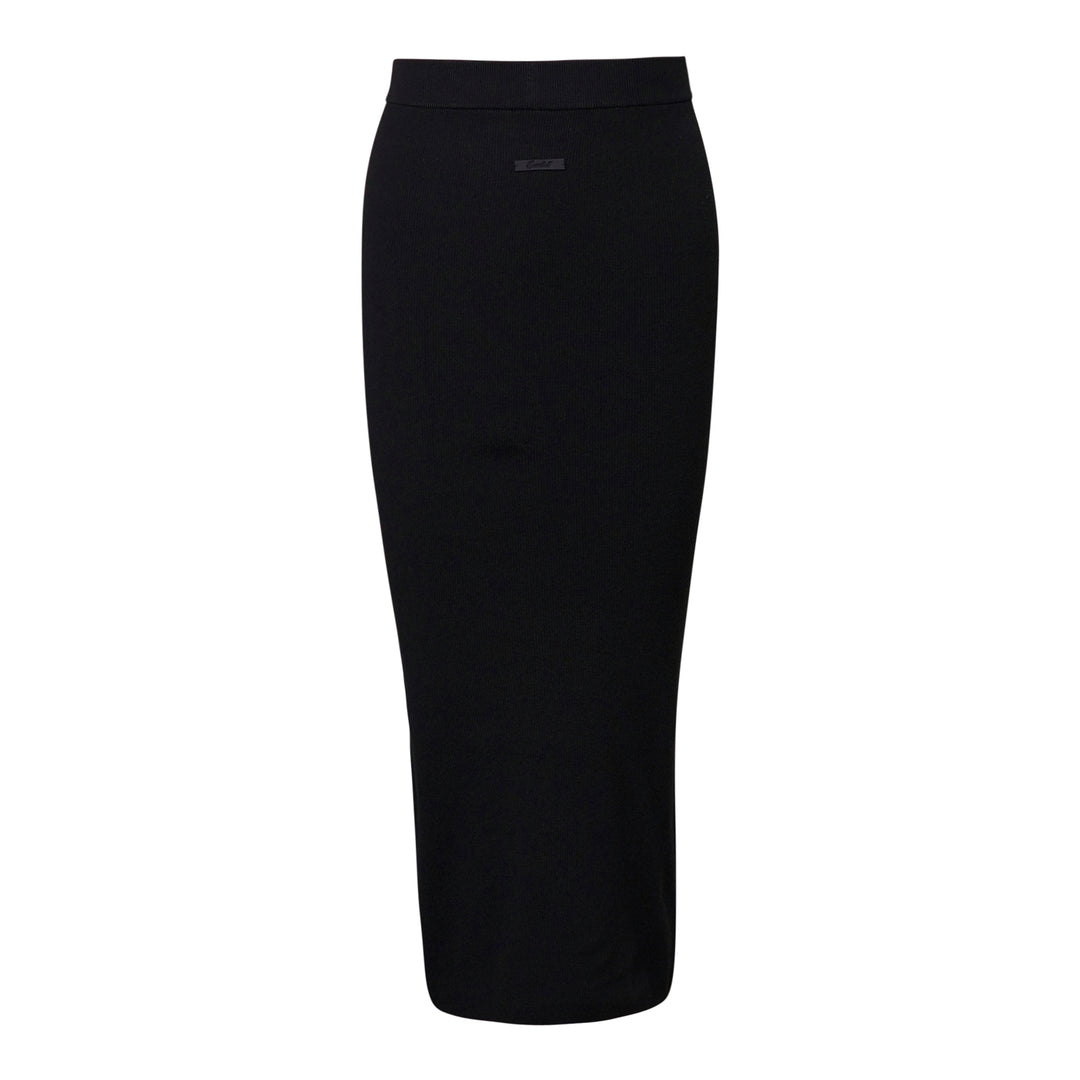Fear of God Essentials black rib knit long midi skirt with wide elasticated waistband and tonal rubber logo tab, flat lay on white background