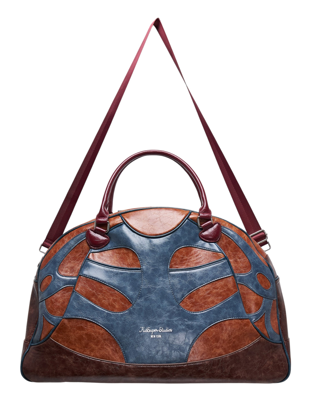 KidSuper Studios bowling bag in blue and tan patchwork faux leather with burgundy top handle and shoulder strap