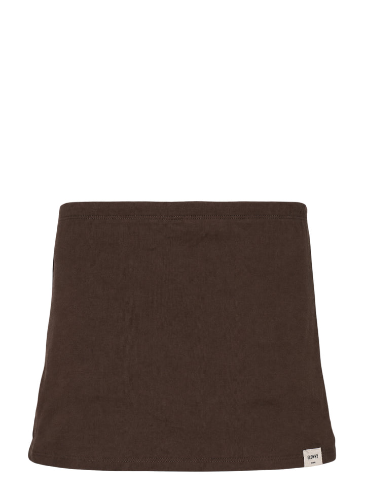Glowny Classic Mini Skirt in dark espresso brown jersey with a low-rise waistband, A-line silhouette, and woven Glowny label at the hem