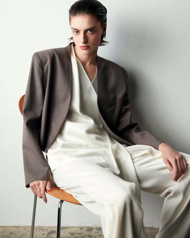 Club21 Collection Clemence black matte acetate satin sleeveless wrap top with deep V-neckline and asymmetric draped handkerchief hem, shown on a white background