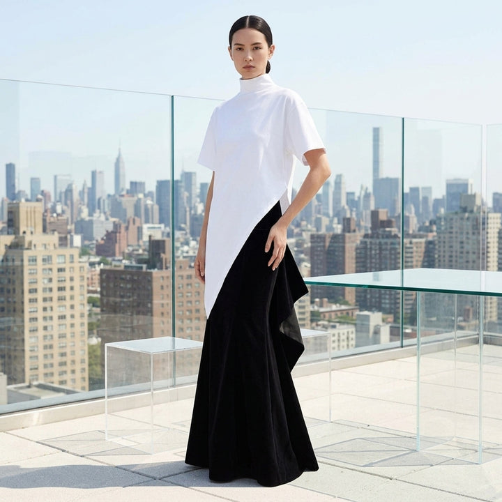 Alaïa black cotton velvet column maxi skirt with structured wide waistband, hip patch pockets, and a subtle flare at the hem, shown on a white background - lifestyle