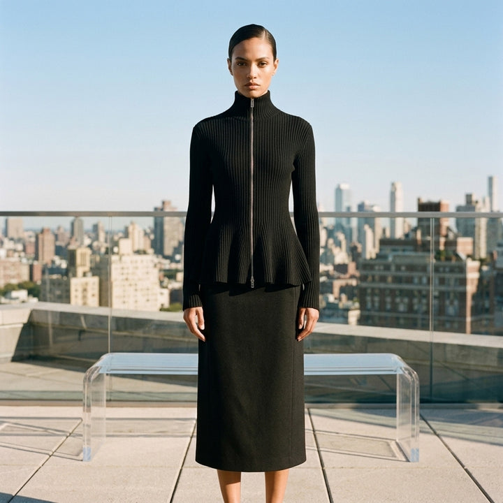 Alaïa Engineered Rib Peplum Cardigan in black with full-length silver zip, high mock neck, and flared peplum hem - lifestyle