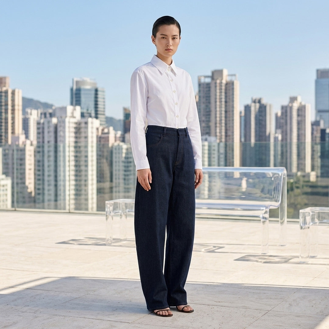 Alaïa round pants in dark navy wool denim with a high waist, curved barrel leg and contrast topstitching, shown from the front - lifestyle