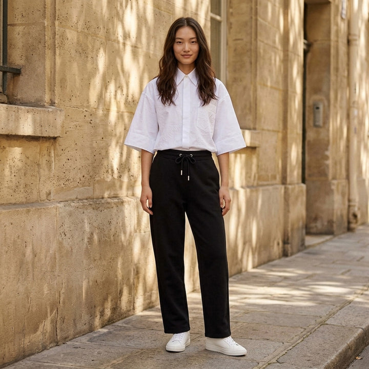 AMI black drawstring sweatpants with ribbed waistband and wide straight leg, shown from the front - lifestyle