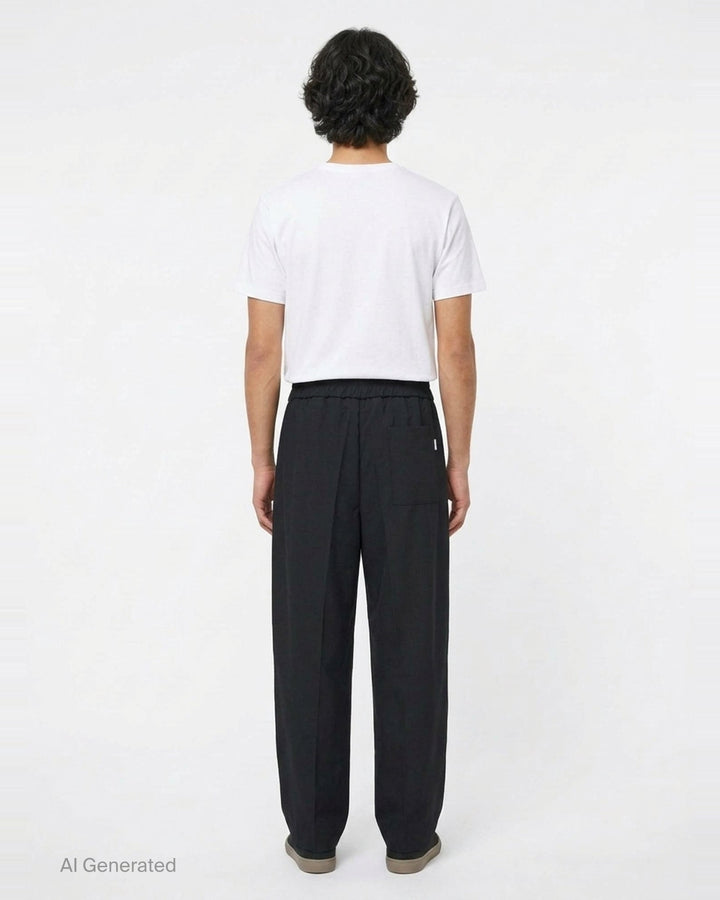 AMI black elasticated waist trousers with drawstring tie, relaxed tapered silhouette and pressed front creases, front view - back