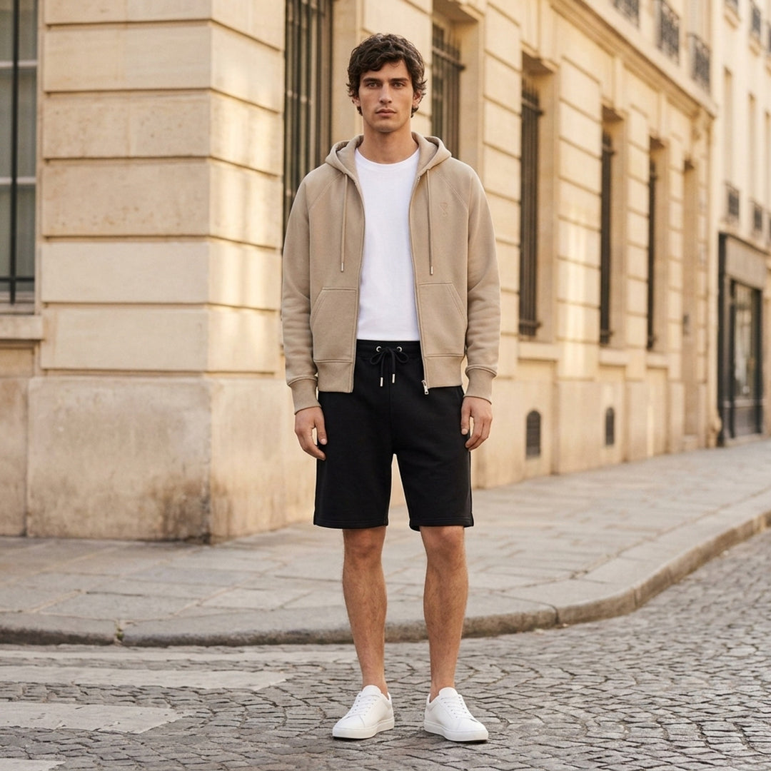 AMI Tonal Emboss Shorts in taupe cotton fleece with drawstring waistband, silver-tone aglets, and subtle logo emboss detail, laid flat on white background - lifestyle
