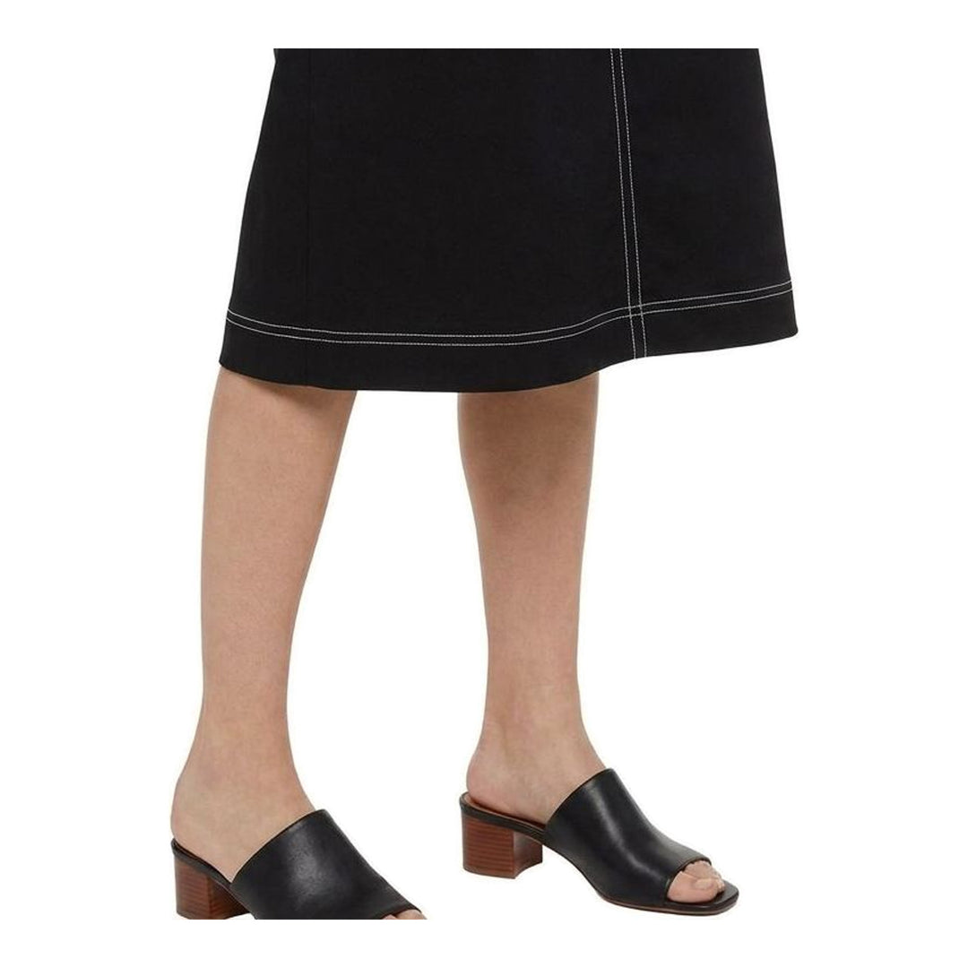 Model wearing an Anaabu black sleeveless midi dress with a voluminous A-line silhouette, asymmetric handkerchief hemline, and fine metallic stud trim at the neckline and hem - packshot