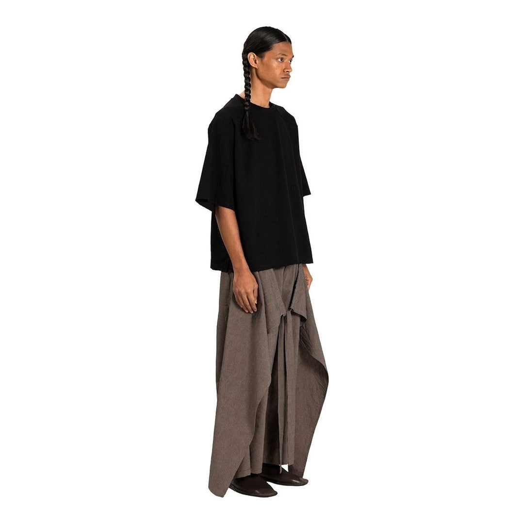 Model wearing the Anaabu Boxy Short Sleeve Tee in black — an oversized, dropped-shoulder silhouette styled over a taupe wide-leg trouser skirt - packshot