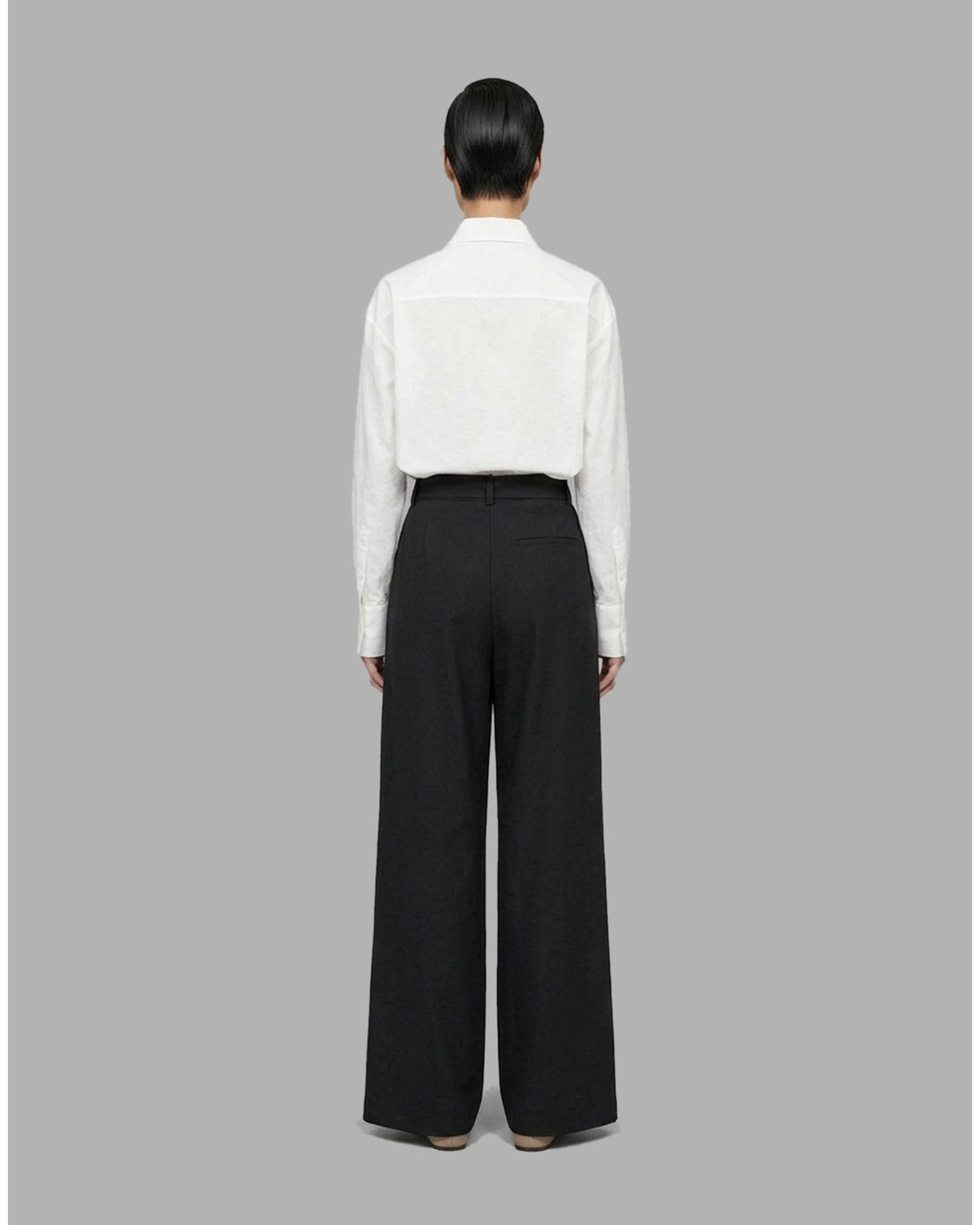 Black high-waisted wide-leg pants with front pleats and a self-tie belt at the waist, shown from the front - back