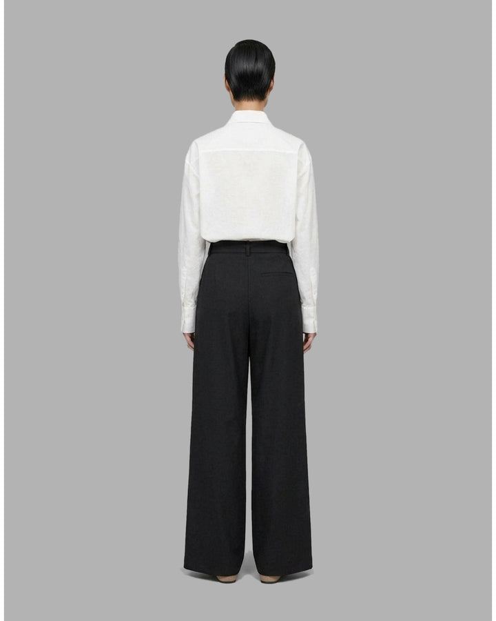 Black high-waisted wide-leg pants with front pleats and a self-tie belt at the waist, shown from the front - back