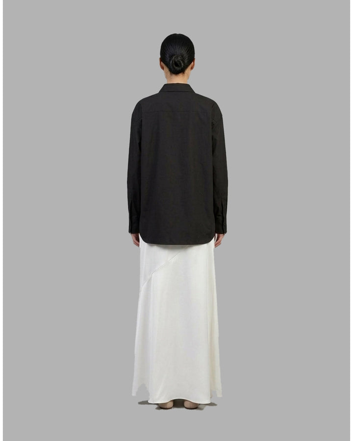 Ivory matte acetate-mix maxi skirt with a diagonal seam and flared hem, shown from the front - back