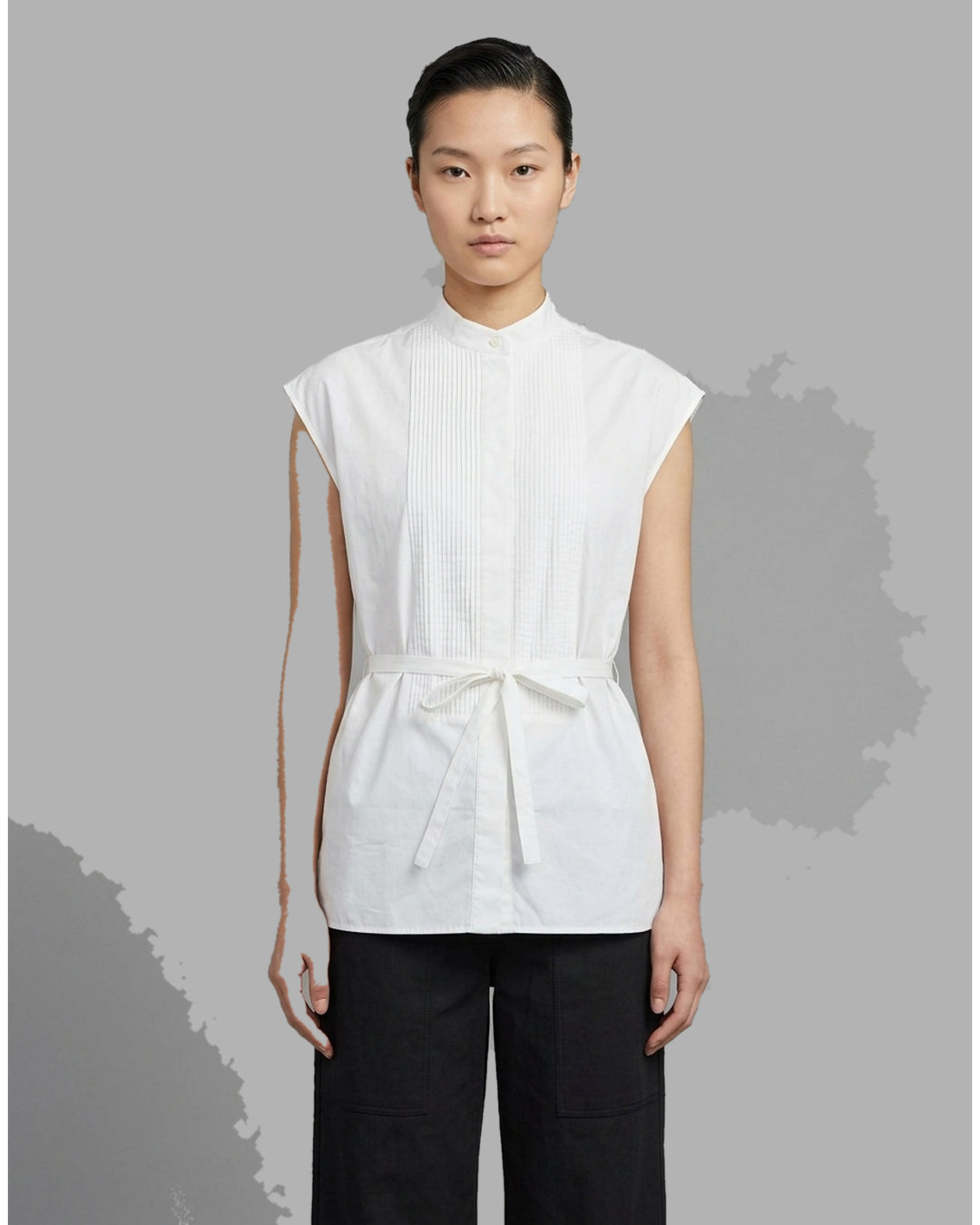 Black sleeveless cotton shirt with pintucked bib front, mandarin collar and self-fabric waist tie - front