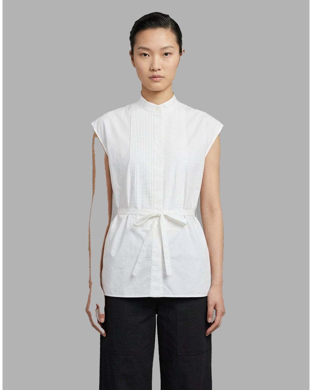 Black sleeveless cotton shirt with pintucked bib front, mandarin collar and self-fabric waist tie - front