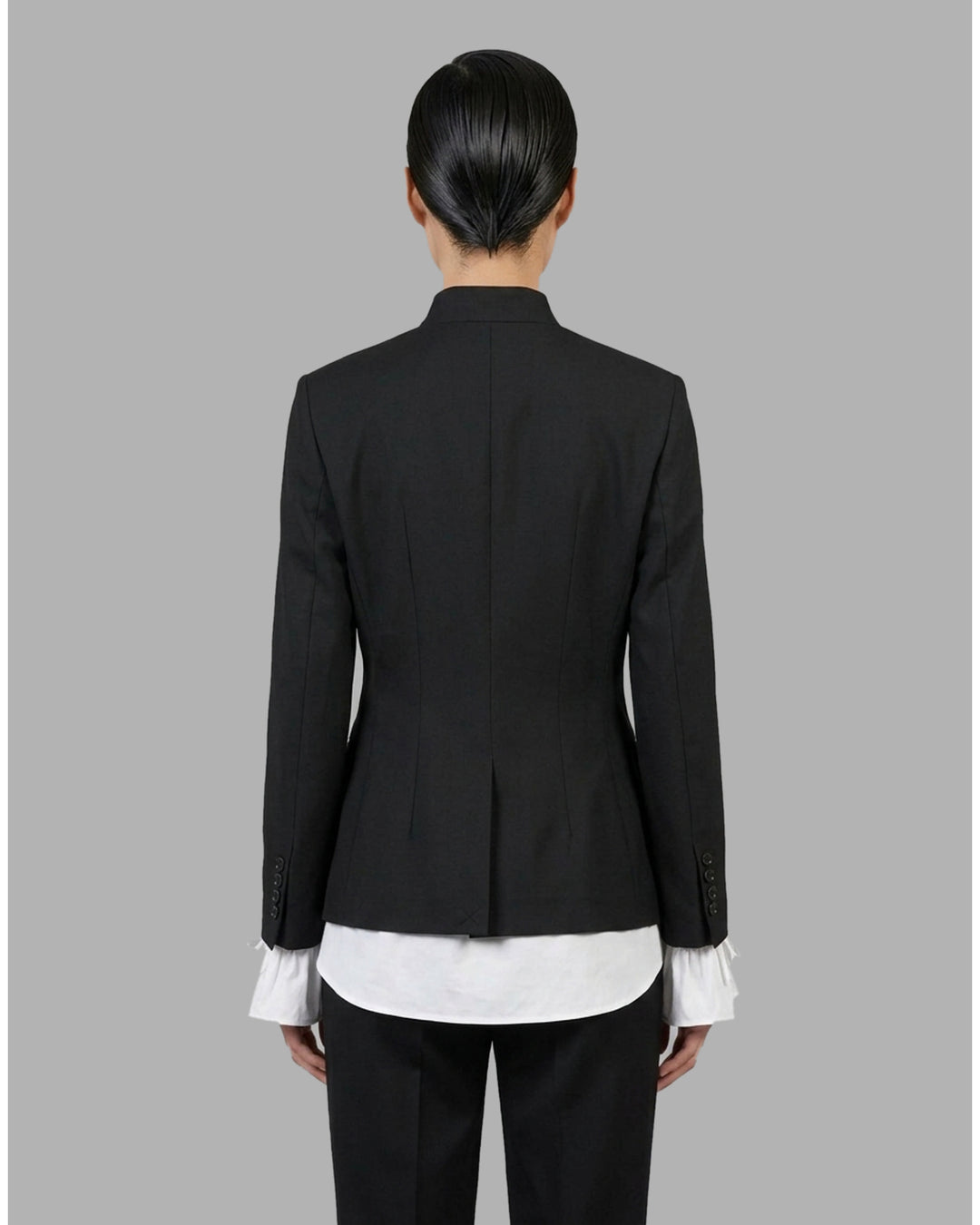 Black wool-mix tailored jacket with asymmetric button front, stand collar, welt chest pocket and flap hip pockets - back