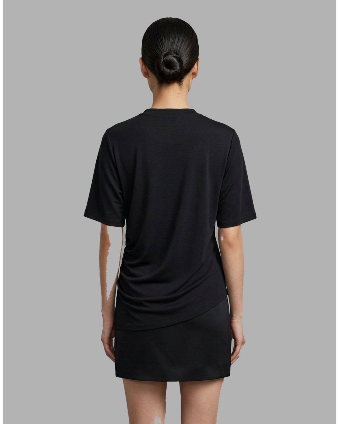 Black short-sleeve crew neck jersey tee with gathered side draping and an asymmetric hem, shown flat against a white background - back