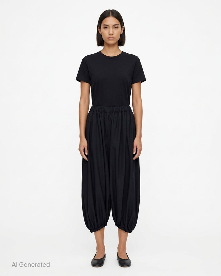 Black balloon pants with an elasticated waist and gathered hems by Comme des Garçons - front