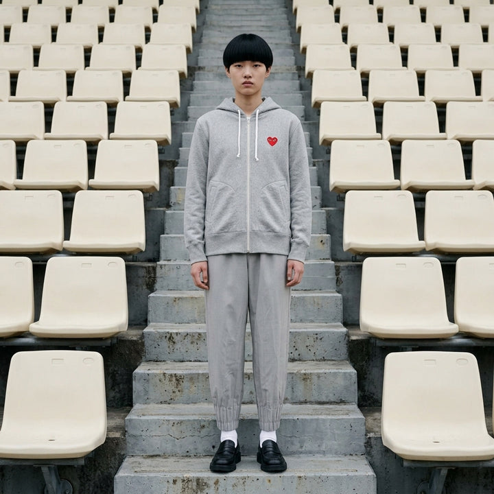 Comme des Garçons PLAY heather grey zip hoodie with embroidered red heart logo at the chest and drawstring hood - lifestyle