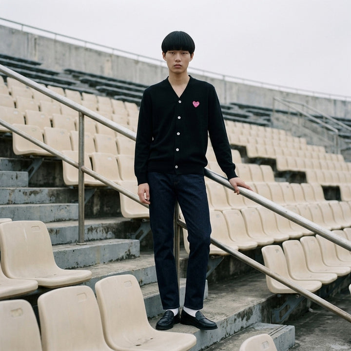 Comme des Garçons PLAY black V-neck cardigan with white buttons and an embroidered pink heart emblem on the chest - lifestyle