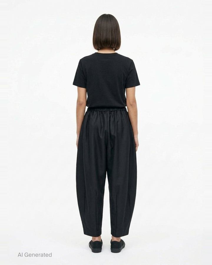 Comme des Garçons black rounded silhouette balloon-leg pants with elasticated waistband and structured vertical seaming, laid flat on white background - back