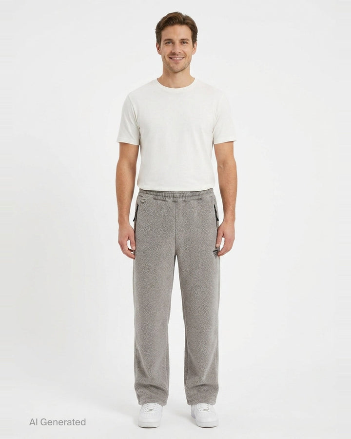 doublet Air Yarn Fleece Pants in heather grey, shown flat — wide-leg silhouette with speckled fleece texture, zip side pockets, elasticated drawstring waistband, and embroidered triangle logo patch at the hip - front