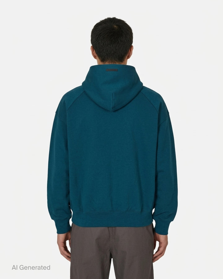 Fear of God Essentials Classic Raglan Hoodie in deep teal with white script logo across the chest and tonal textured shoulder panels - back