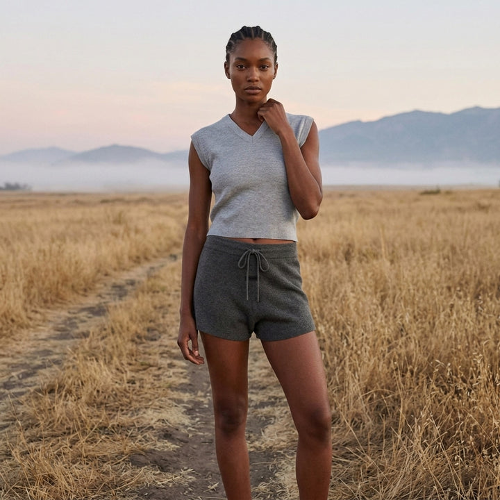 Fear of God Essentials women's heather grey fine rib-knit sleeveless cropped top with a V-neckline and structured shoulders, displayed flat on a white background - lifestyle