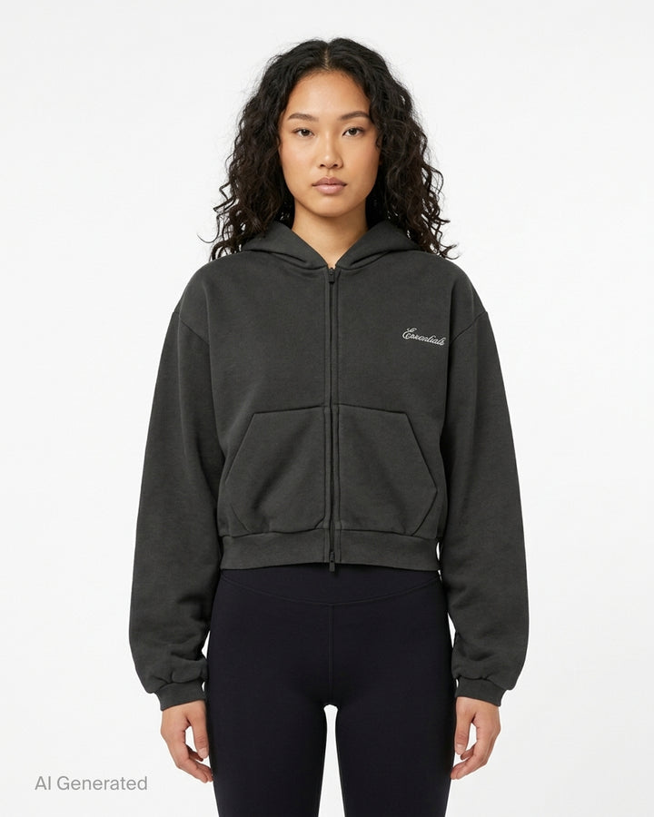 Fear of God Essentials women's modern cropped zip hoodie in washed black with embroidered script Essentials logo on the chest and front hand pockets - front