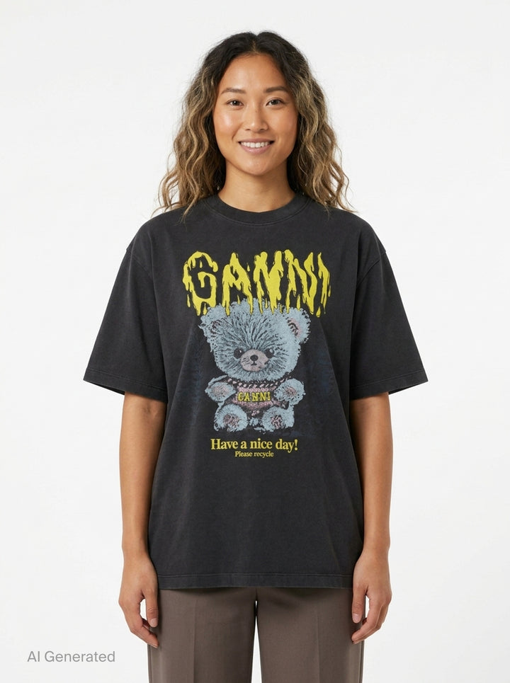 Ganni Heavy Cotton Forest Ted T-shirt in washed black, featuring a yellow drip-style Ganni logo above a teddy bear mascot graphic and 'Have a nice day! Please recycle' slogan print - front