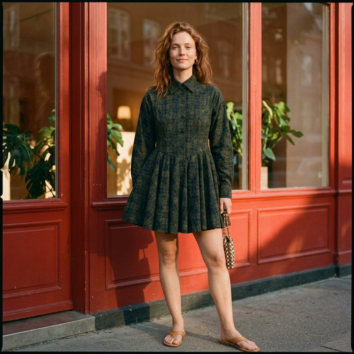Ganni Printed Stretch Cotton Peplum Dress in dark green floral tartan, featuring a point collar, button-through front, and voluminous gathered skirt with ruffle hem - lifestyle