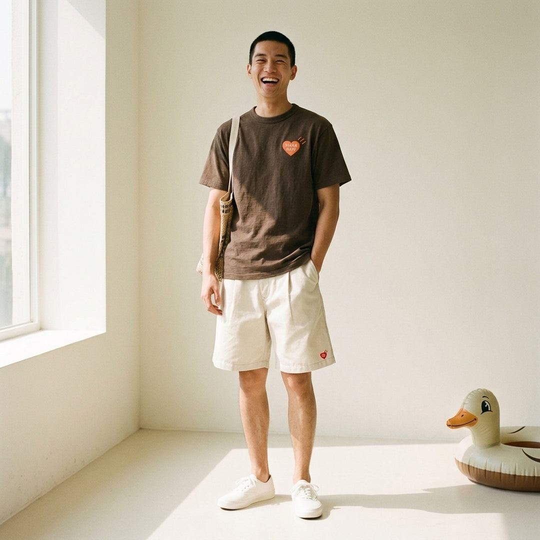 Human Made brown short-sleeve graphic T-shirt with an orange heart logo print at the chest and a red woven label at the neck - lifestyle
