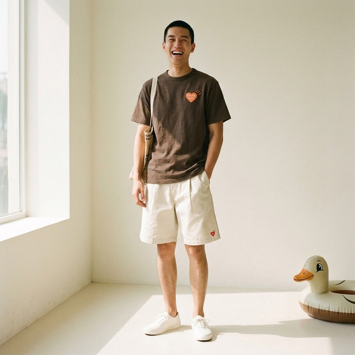 Human Made brown short-sleeve graphic T-shirt with an orange heart logo print at the chest and a red woven label at the neck - lifestyle