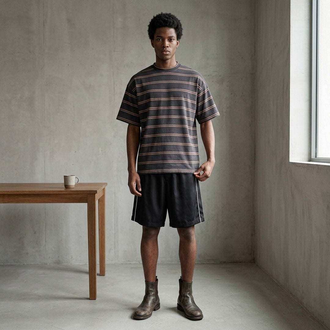 Jil Sander charcoal short sleeve t-shirt with terracotta horizontal pinstripes and tonal embroidered monogram at chest, crew neckline, oversized fit, on white background - lifestyle