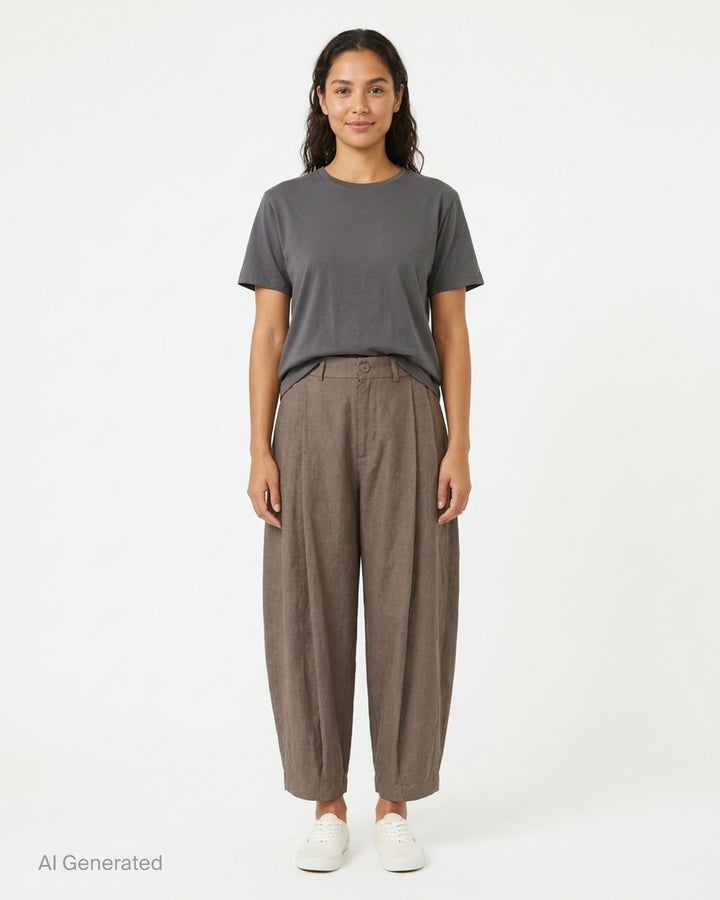 Lauren Manoogian black pleated taper trousers with a high waist and curved leg, shown from the front - front