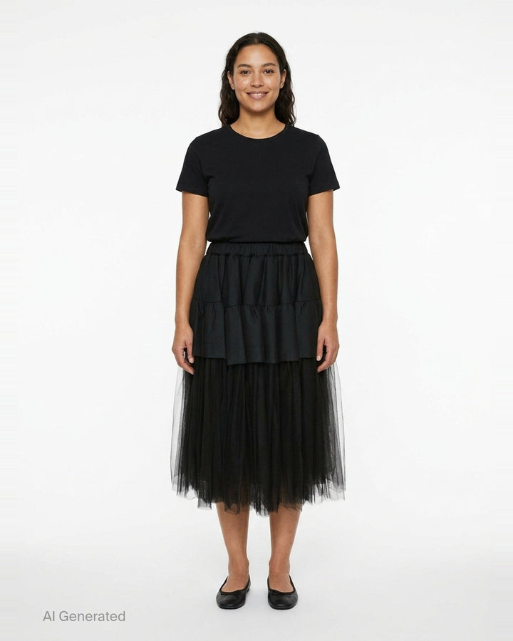 Noir Kei Ninomiya black tiered ruffle skirt with gathered elastic waist and sheer tulle underlayer, midi length, on white background - front