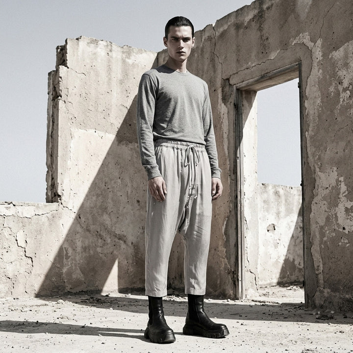 Rick Owens grey drawstring cropped pants with a dropped crotch, elasticated waistband and fluid, semi-sheer fabric, shown from the front - lifestyle