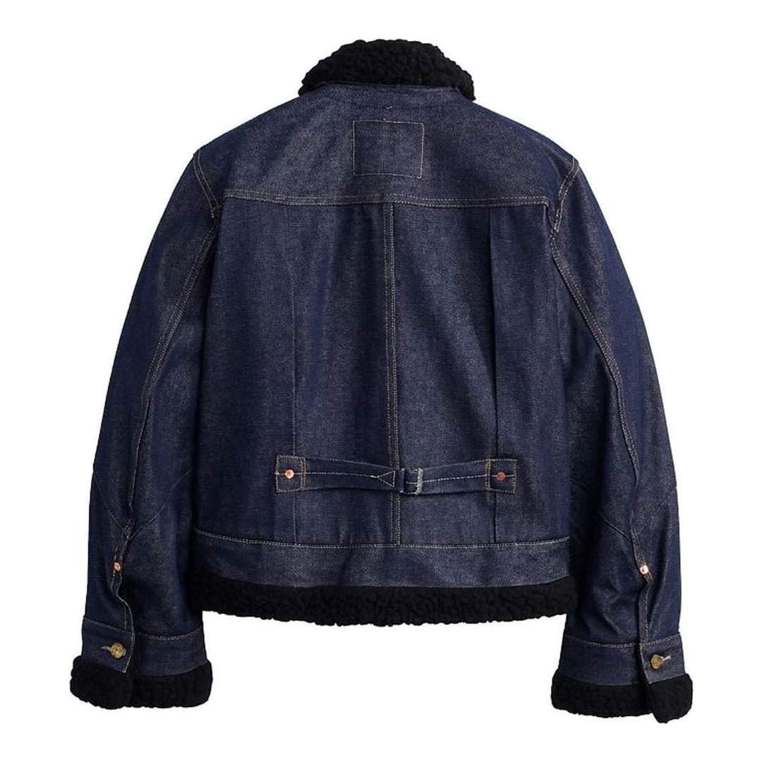sacai x Levi's women's indigo denim trucker jacket with cream sherpa collar, cuffs and hem, leather patch pocket and buckled side straps - packshot