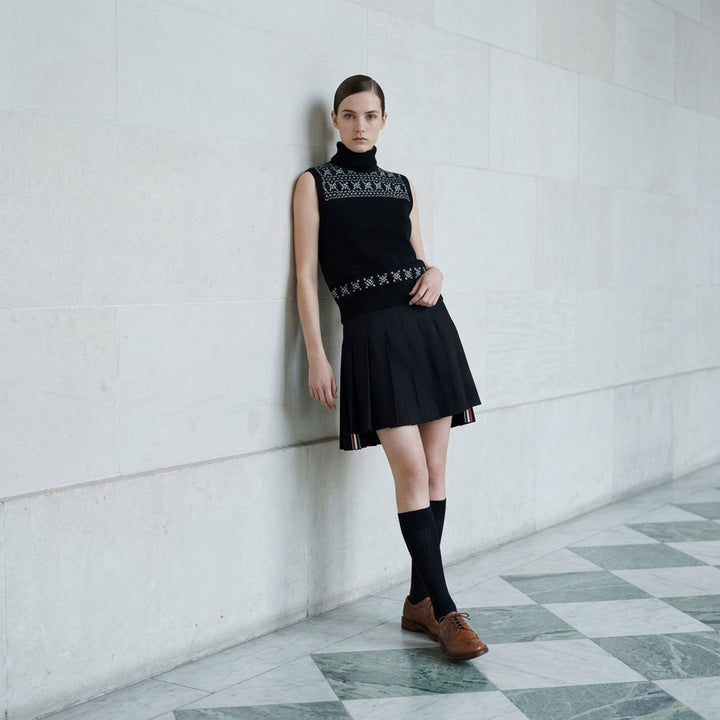 Black sleeveless turtleneck knit vest with white and grey Icelandic Fair Isle snowflake pattern across the yoke and hem - lifestyle